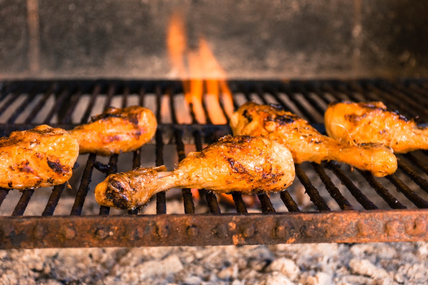 Pilons de poulet marin&eacute;s en cours de cuisson au barbecue